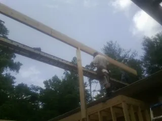Carpenter setting a ridge beam over a new addition frame — Ice Dam Removal by Roofing Brothers in Dry Run