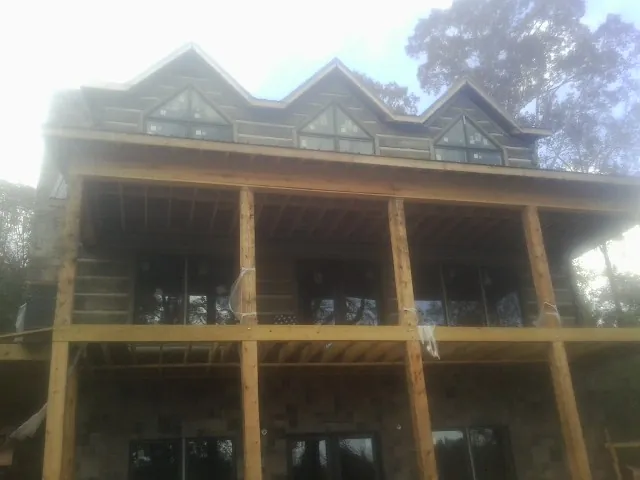 Dormers and porch framing on a large log home under construction — Roof Coating work by our crew in Dry Run